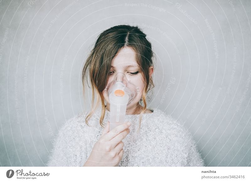 Young woman using a breathing mask covid 19 coronavirus pandemic illness oxygen infected contagious infection allergy asthma health healthy breathing medical