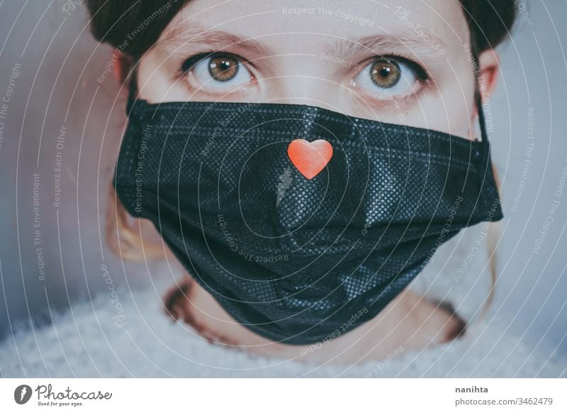 Young woman wearing a mask with a red heart on it covid 19 coronavirus breath pandemic illness hope love help solidarity empathy care infected contagious