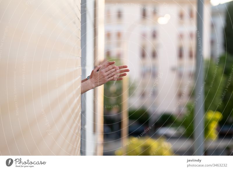 Woman clapping in the window in support of people who fight against the coronavirus epidemic balcony woman girl health building global you infection house