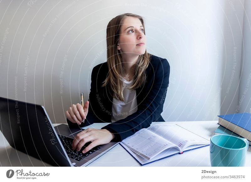 Smiling young female entrepreneur sitting at home working with her laptop woman table professional 1 businesswoman technology computer job wireless freelance