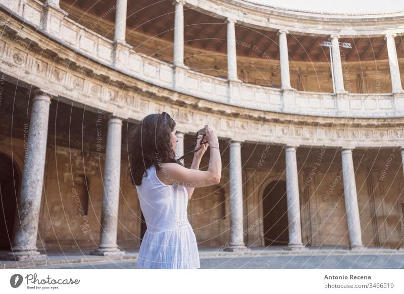 Tourist woman taking pictures to La Alhambra in sunny day. Carlos V palace city view architecture built structure building travel travel destination landmark