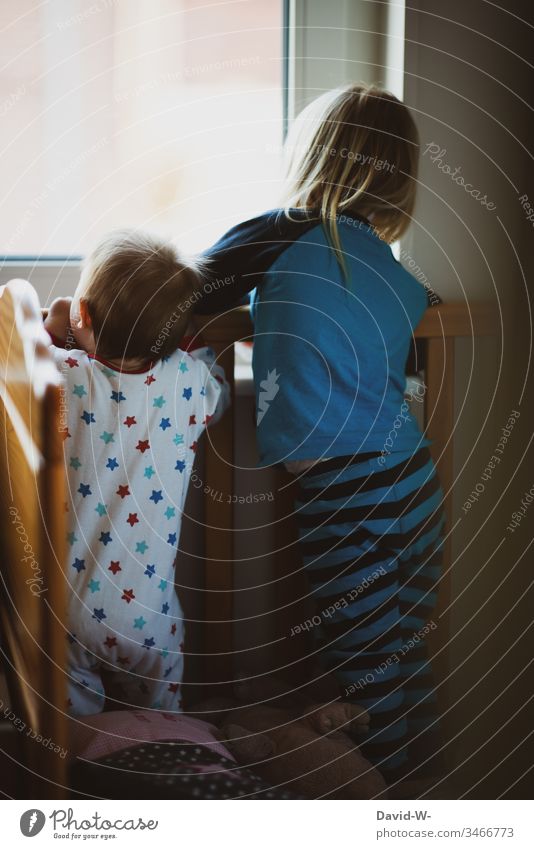 Children siblings look curiously through the window Baby Brothers and sisters children Observe Window inquisitorial Girl Small Sister Boy (child) Toddler Pyjama