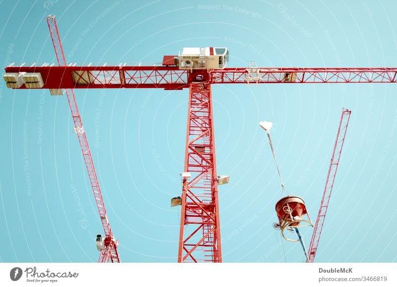 Three red cranes with a concrete mixer in front of a blue sky Crane Construction site Exterior shot Sky Blue Colour photo Work and employment Day Steel Tall