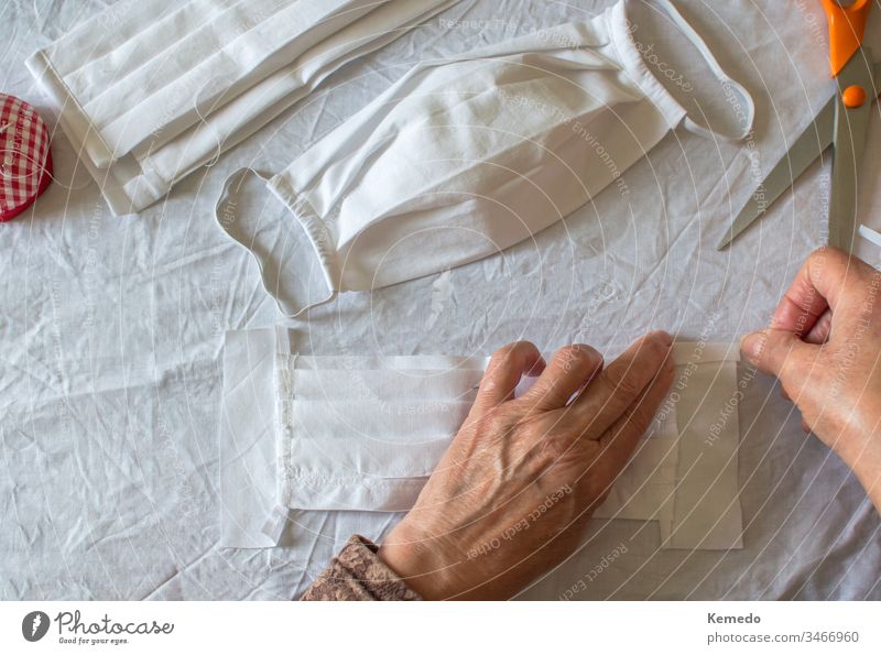 Top view of woman make a protective mask at home against coronavirus. Person sewing medical mask because the lack of stock in stores, close up. Copy space left.