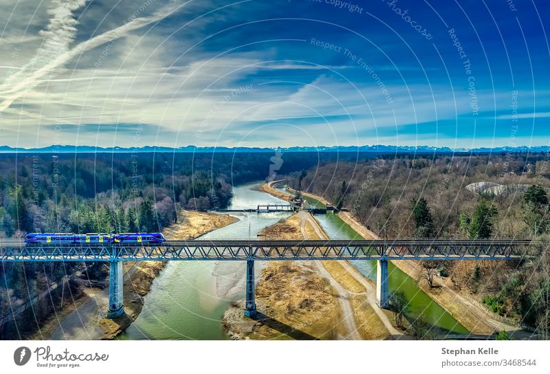 A train crosses a railway bridge over a river with mountains in the background Train Bridge River Railroad Transport Exterior shot Train travel Landscape Nature