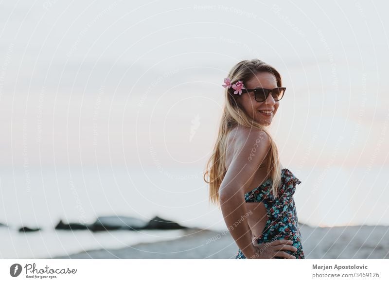 Young woman enjoying sunset on the beach adult attractive beautiful beauty carefree coast dawn enjoyment evening female freedom girl happiness happy holiday