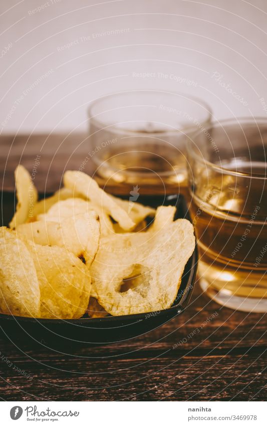 Still life of pale ale beer and chips party food food and drink alcoholic drink potatoes aperitif appetizer snacks date two glass wood wooden background cuisine