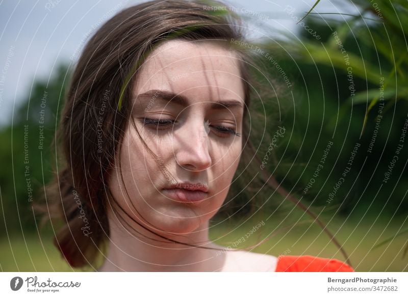 Girl in the red dress green hair Young woman grass relax Wind