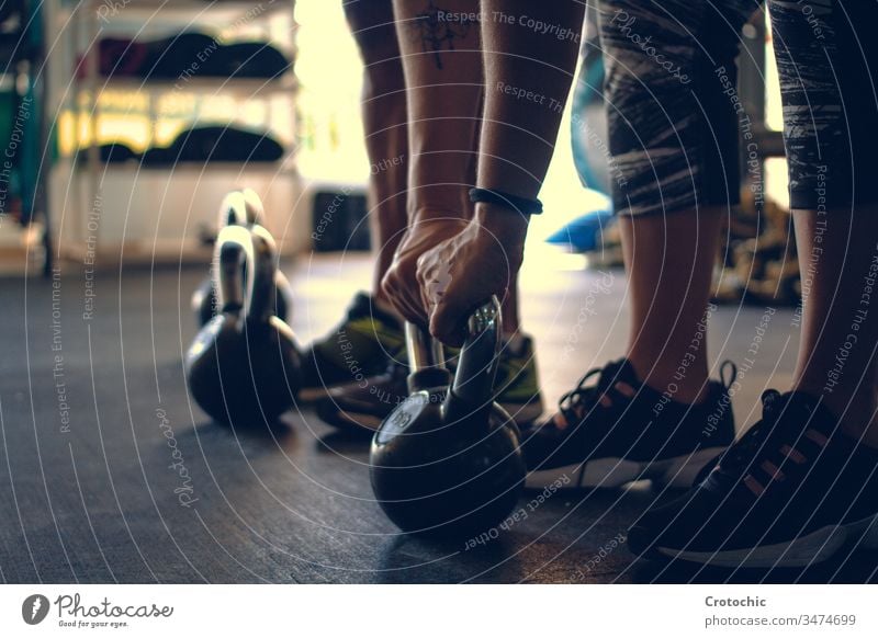 Detail of a man holding a kettlebell placed on the floor of a gym athlete weights determination exercising indoors lifestyles strength vitality wellbeing people