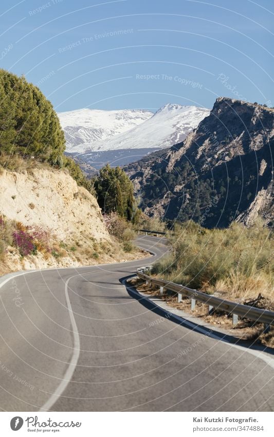 Road through the Spanish Sierra Nevada with snow-covered mountains in the background Andalucia Street Mountain Snow Snowcapped peak Spring Spain Curve