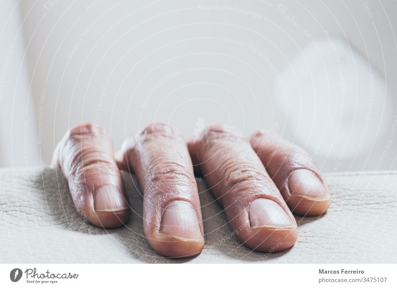 man's hand fingers on the edge of the sofa alone escandinavian isolated interior male person background people white caucasian human concept adult business arm