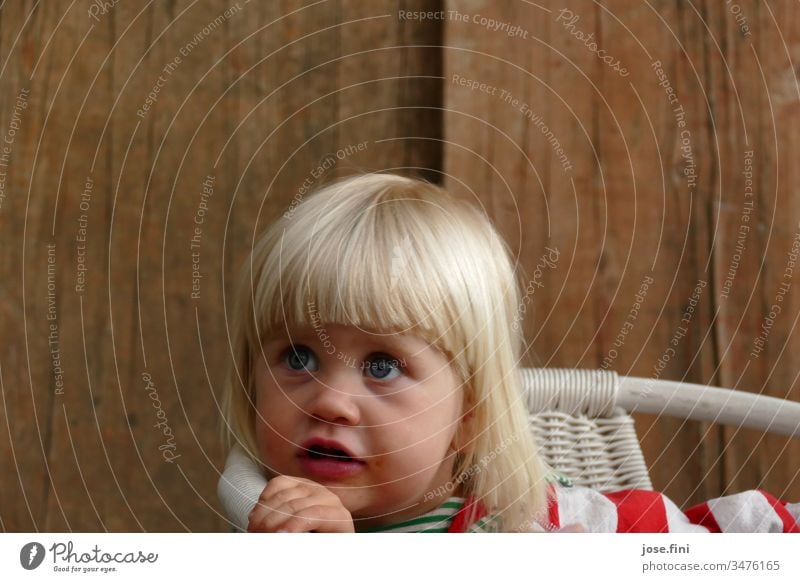 Little girl sitting on a chair and looking up with big blue eyes Portrait photograph Day Natural Love Blonde little girl Child big eyes conversation eloquent