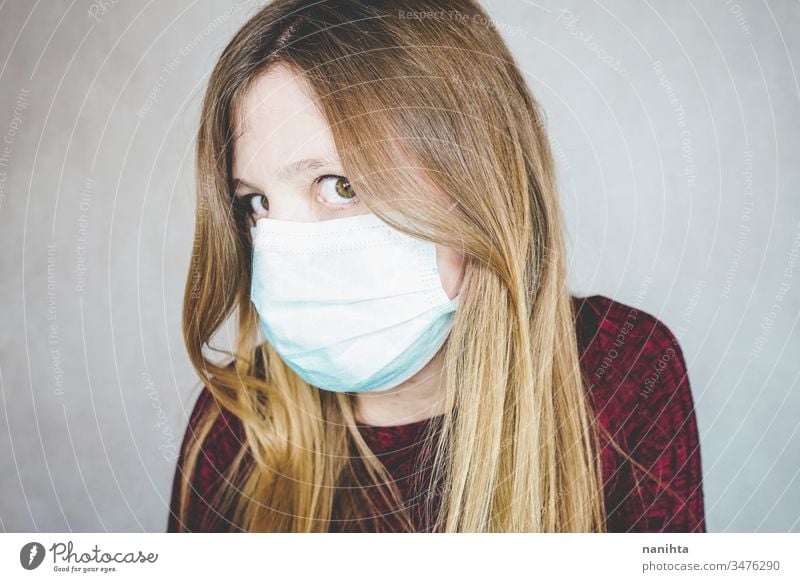 Young woman wearing a protective face mask covid 19 flu influenza coronavirus pandemic epidemic illness respiratory illness social distance contagion risk