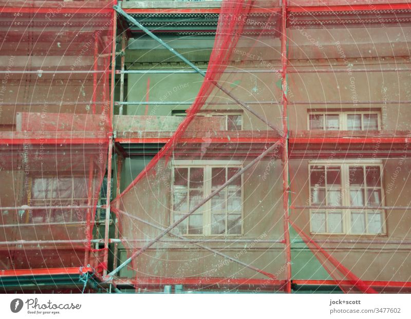 Renovation of the green facade with reddish scaffolding Construction site Facade Scaffold Covers (Construction) Authentic Protection Change Modernization