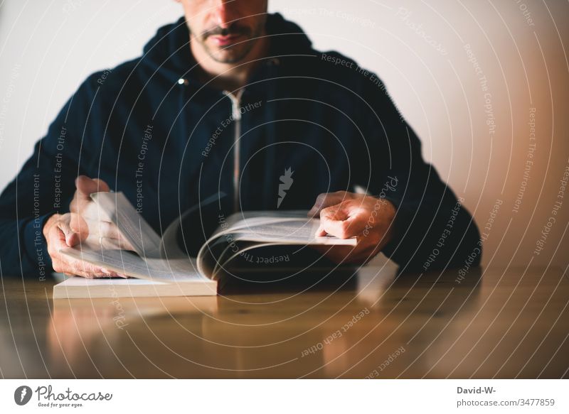 Man reads a book and turns pages to look up something Book Reading Movement To leaf (through a book) turn over Desk Table Know Study Page lookup Anonymous