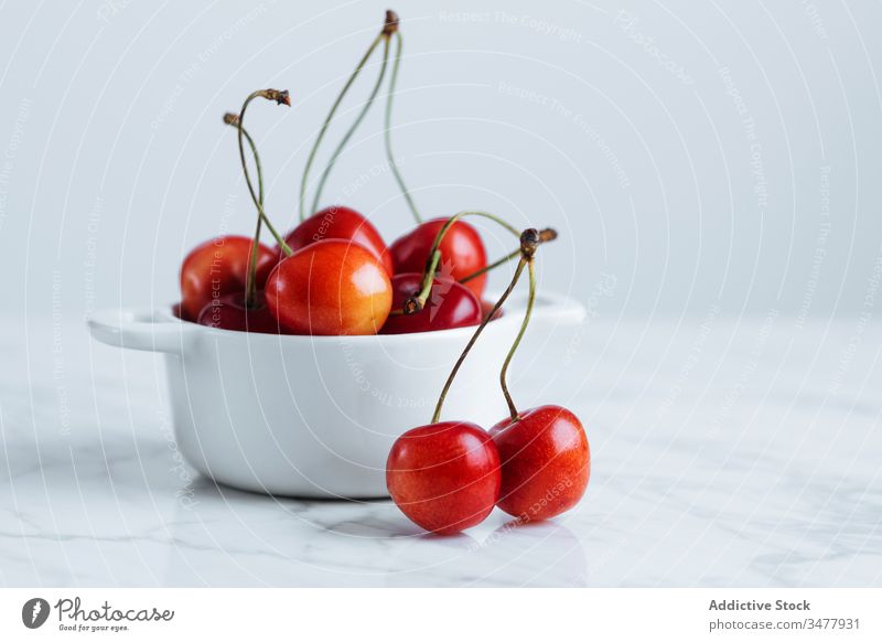 Red cherry in white bowl on table red berry fruit fresh ripe natural food healthy pot pile plant stalk vitamin sweet tasty delicious raw season summer colorful