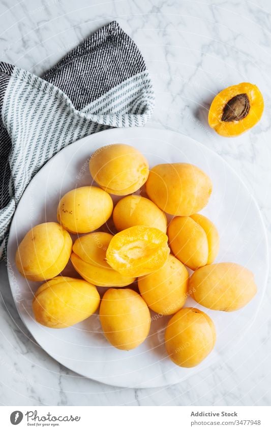 Plate with fresh apricots on white marble table fruit ripe plate yellow orange natural food delicious tasty healthy organic ingredient nutrition meal cuisine