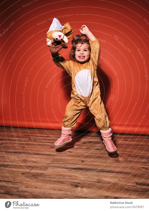 Cute little girl in deer costume jumping in studio kid cute happy joy cheerful adorable active child female infant innocent childhood disguise energy positive