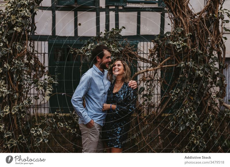 Happy couple in love hugging on street embrace city romantic together happy affection date kiss france bayonne urban bonding fence lifestyle cheerful tender