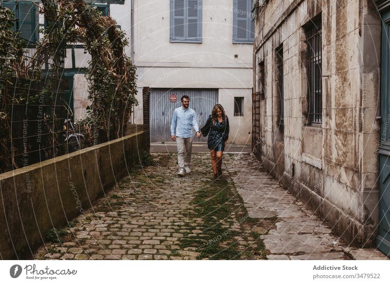 Happy couple walking on city street happy together cheerful smile casual romantic love relationship lifestyle urban girlfriend boyfriend affection old france