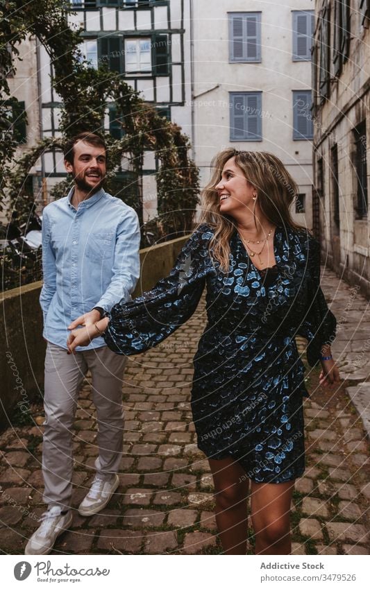 Happy couple walking on city street happy together cheerful smile casual romantic love relationship lifestyle urban girlfriend boyfriend affection old france