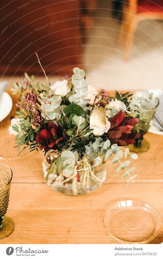 Flowers and plant twigs on a vase decorating a wooden table flowers bunch leaf bouquet water petal concept glass fresh bloom interior vintage nature decorative