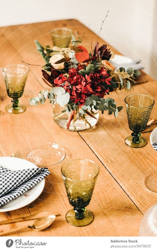 Flowers and plant twigs on a vase decorating a wooden table flowers bunch leaf bouquet water petal concept glass fresh bloom interior vintage nature decorative