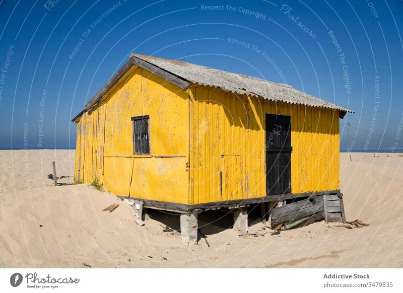 Old shabby house on sandy beach small coast building facade rural countryside exterior architecture sunny blue sky construction structure residential window