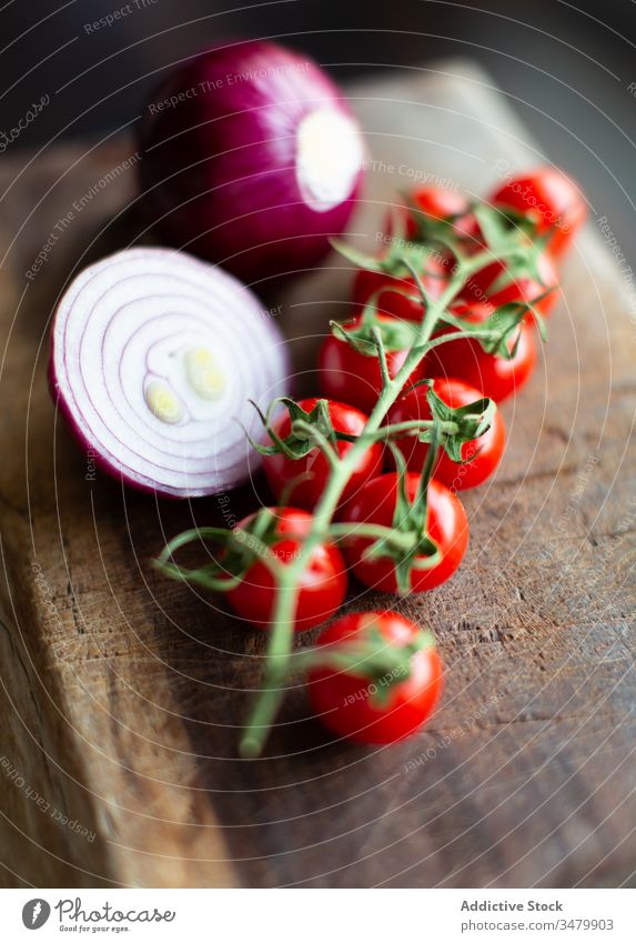 Tomatoes and onion on wooden board tomato red fresh cherry bunch ripe food vegetable cut healthy vegetarian bulb organic ingredient nutrition composition