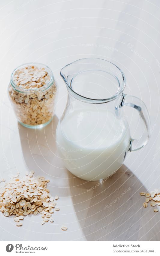 Jar of milk and oatmeal flakes on table jar vegan healthy natural nutrition food glass diet organic breakfast vegetarian drink ingredient morning cereal