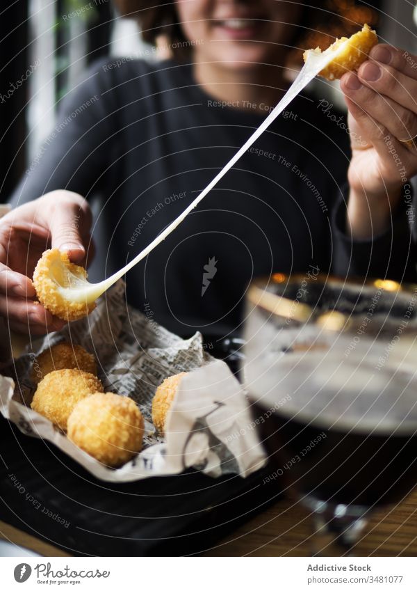 Woman eating cheese balls in cafe woman fried snack delicious fast food crispy tasty fill mozzarella stretch meal female smile positive cuisine table nutrition