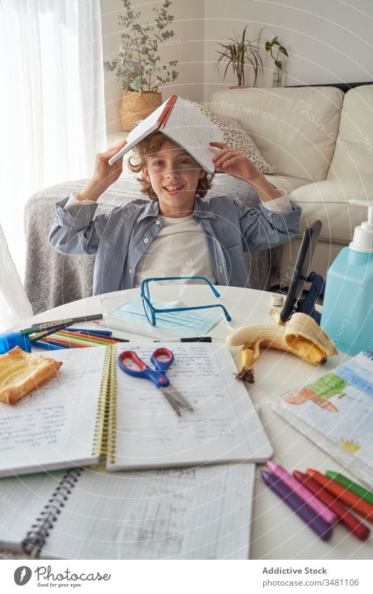 Bored boy yawning during online studies remote education quarantine textbook bored smartphone home kid child study lifestyle mask snack sandwich notebook banana