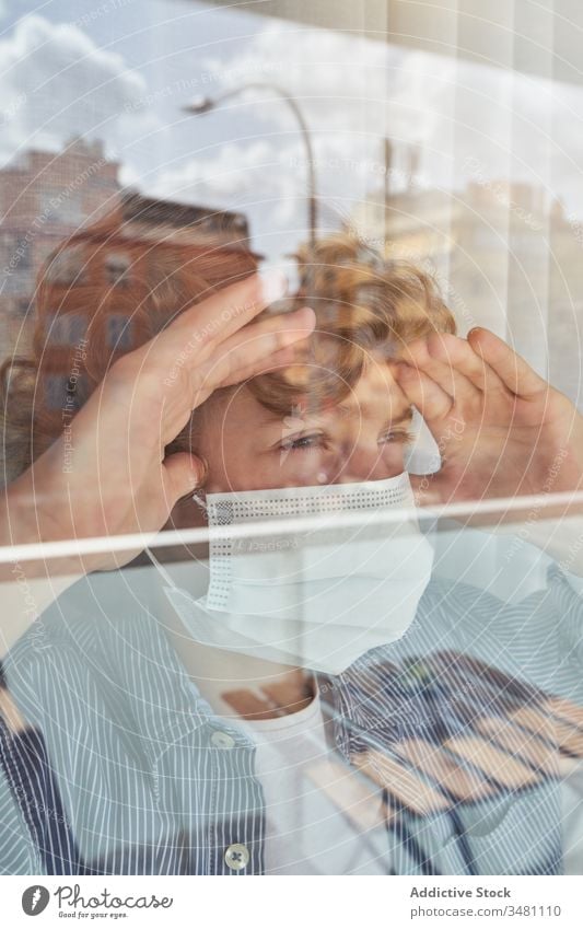 Boy behind window during quarantine boy mask medical home frown pandemic coronavirus covid 19 child kid childhood sad unhappy hygiene health care infection