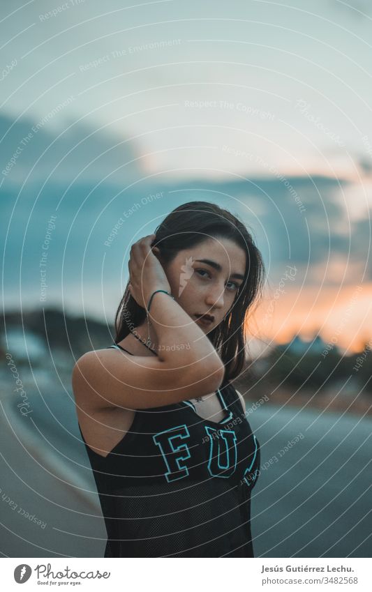 young girl with serious look with a beautiful sunset in the background Life Spain Colour photo Upper body Front view Hipster people youthful