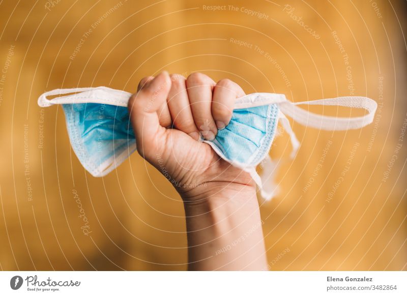 Woman hand pressing a blue breathing medical respiratory mask. waiting for the epidemic to end. Chinese pandemic coronavirus, virus covid-19. Quarantine, prevent infection concept.