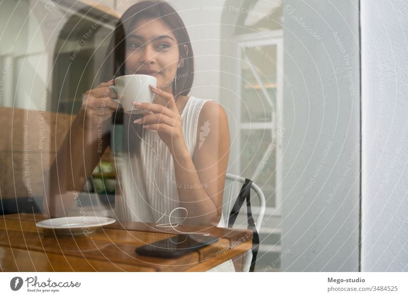 Young woman drinking a cup of coffee at coffee shop. young portrait latin outdoors cafe brunette time off confident leisure free time lifestyle refreshment