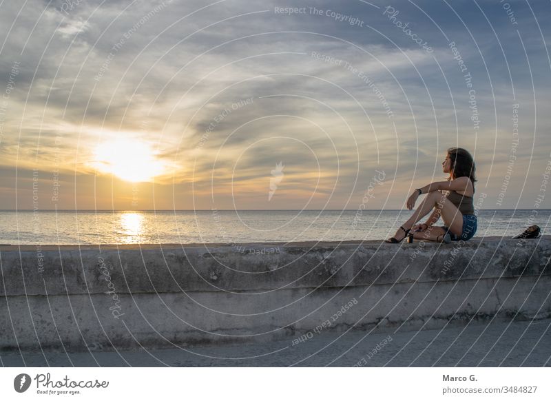 Young woman looking the sunset sitting on pier romantic destination havana america fortress capital attraction sky cityscape old ocean dusk tourism water