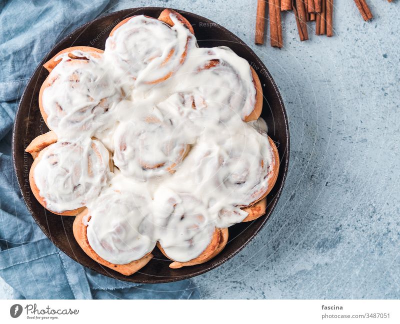 Vegan cinnamon rolls with topping, top view bun swedish frosting skillet vegan kanelbullar pumpkin spice cream cheese flat lay copy space text cinnabon bakery