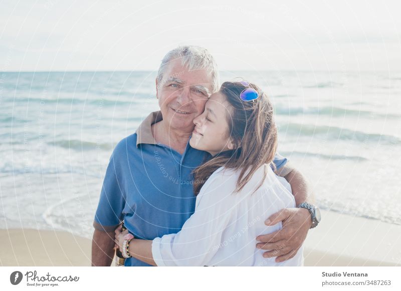 Father and Daughter Embrace at the Beach in the Philippines bond girl children little stubble field snuggling bonding having fun fatherhood adorable hugging