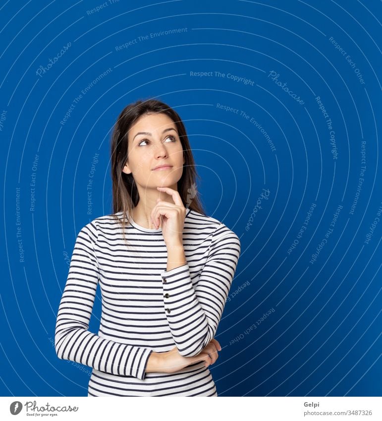 Brunette young woman wearing a striped T-shirt girl person blue thoughtful pensive think imagine imagination idea solution doubt doubtful thinking smart