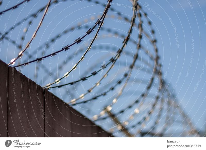 on the wall on the lookout. Sky Cloudless sky Industrial plant Factory Wall (barrier) Wall (building) Fence Barbed wire Barbed wire fence Stone Metal Line