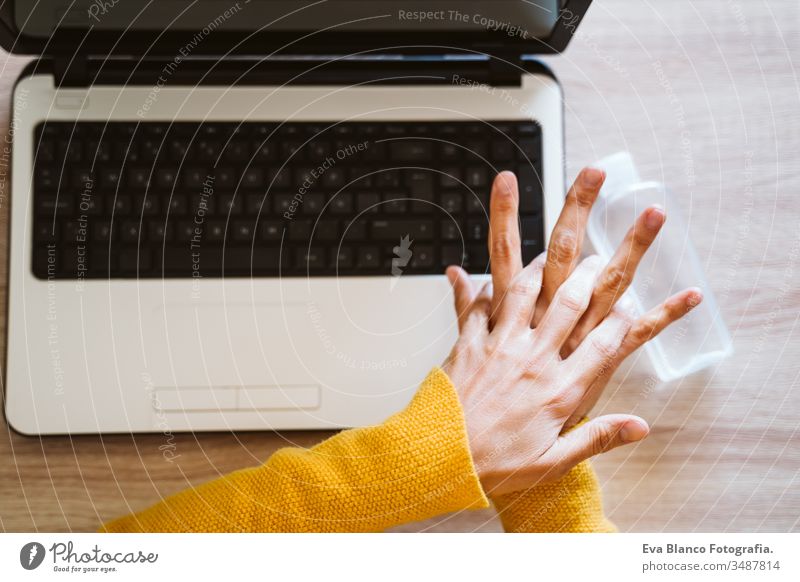 young woman working on laptop at home, using hand sanitizer alcohol gel. Stay home during coronavirus covid-2019 concept disinfectant hands antibacterial