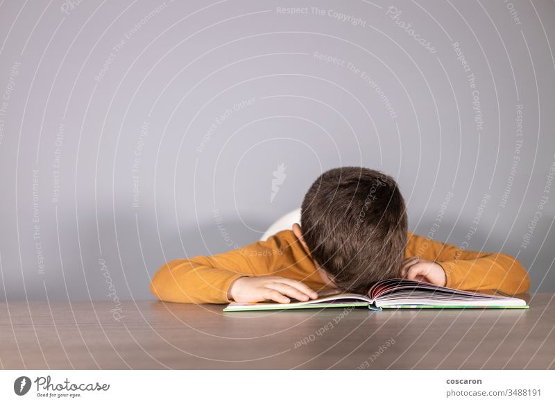 Angry schoolboy with learning difficulties angry blue book caucasian child class classroom cute dejected desk difficulty dyslexia education exhausted face