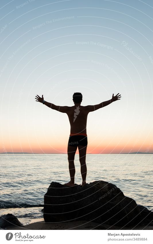 Silhouette of a man enjoying sunset on the beach active adventure alone back beauty free freedom guy handsome happiness happy health holiday landscape leisure