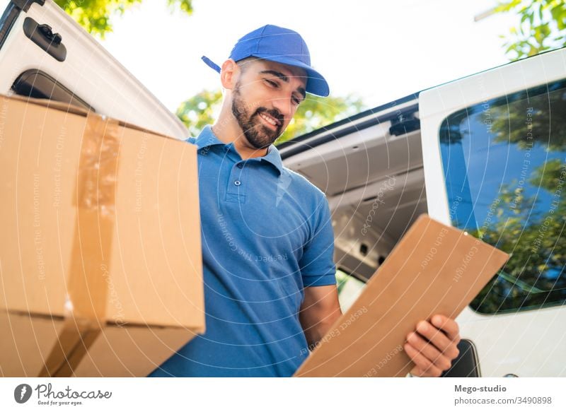 Delivery man unloading cardboard boxes from van. male service package delivery shipping industry work send office closeup logistic consumer carrying profession