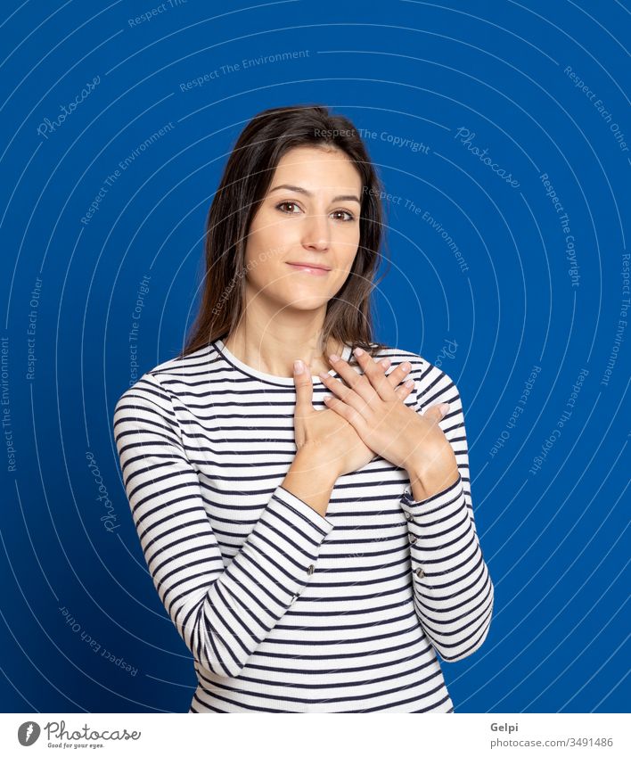 Brunette young woman wearing a striped T-shirt girl person love feel hand together in love romantic happy smile faith heart inspired blue expression gesture