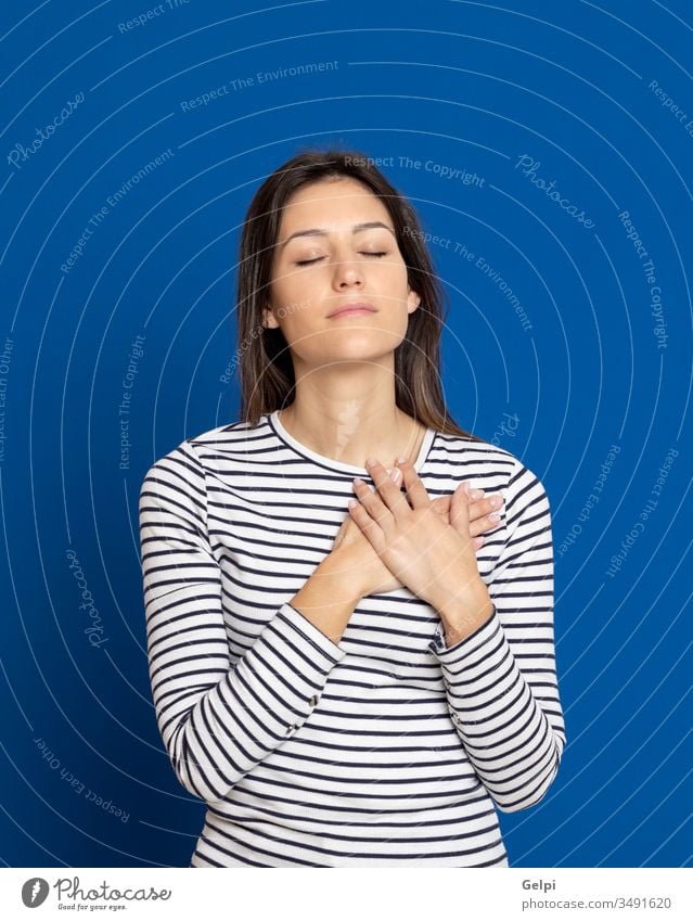 Brunette young woman wearing a striped T-shirt girl person blue love feel hand together in love romantic happy faith heart inspired promise expression gesture