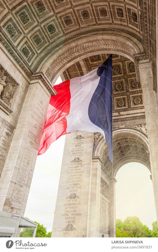 View of Arc de Triomp with flag of France waving in wind on Place de Gaulle in Paris, France paris arch triomphe france monument europe city charles gaulle