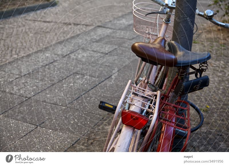 Two bicycles stand close together leaning against a lamppost. Bicycle two Cycling Trip Lean Together togetherness vintage Retro Old luggage carrier Transport