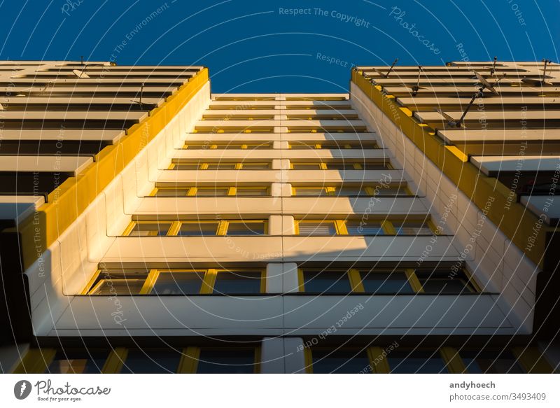 An apartment building with yellow windows in the morning light architecture balconies balcony Berlin block blue blue sky building exterior built structure